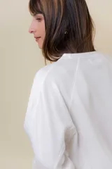 Buzo de manga larga color verde claro, con cuello redondo y calce relajado.