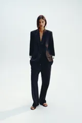 Pantalón negro de lino, de tiro alto con cintura elástica ajustable con cordones, bolsillos delanteros y pernera recta.