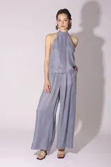Conjunto de pantalón y top de seda color gris, con cuello halter y corte holgado.