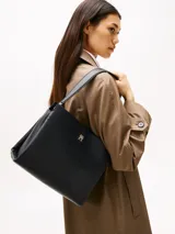 Cartera satchel negra de Tommy Hilfiger con acabado granulado, cierre de cremallera, asa superior, correa extraíble ajustable, bolsillo interior con cremallera e insignia del monograma TH en la parte delantera.