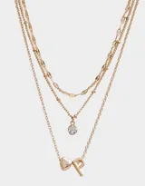 Collar corto dorado multicadena con dije de strass y dije de letra P con corazón.