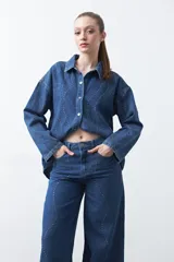 Jean wide leg de color negro con silueta amplia y caída fluida. Presenta detalles de tachas aplicadas que recorren el diseño en forma de ondas. Confeccionado en denim de algodón.