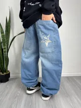 Pantalón de jean celeste, corte holgado, con bolsillos traseros y estampa de estrella en uno de ellos.