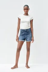 Bermuda de jean celeste, tiro alto, corte mom fit, con trabillas y cinco bolsillos.