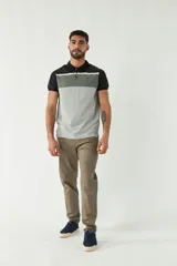 Remera polo de hombre con diseño en bloques de color negro, gris y blanco.