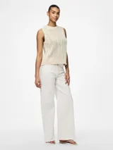 Top tejido color crema, con cuello redondo y sin mangas.