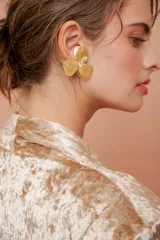 Aros colgantes con forma de flor de tres pétalos color dorado, con un cristal en el centro.