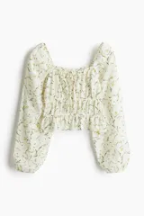 Blusa corta blanca con estampado floral, de tejido arrugado, escote cuadrado elástico con cordón ajustable, mangas globo largas con puños elásticos y costuras elásticas en la cintura para un efecto fruncido.