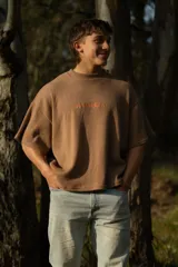 Remera marrón de manga corta confeccionada en punto Prato, con bordado frontal con la palabra 'bouuwana'. De calce relajado y textura suave.