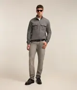 Buzo gris texturizado con cuello alto y cremallera delantera. Tiene mangas largas con puños ajustados, barra ajustada y dos bolsillos en el pecho con solapa y botón.