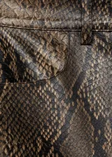 Minifalda marrón con estampado de piel de serpiente, tiro medio, corte recto, cierre frontal con cremallera y dos bolsillos laterales.