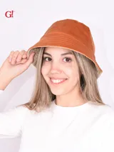 Sombrero tipo bucket color naranja, reversible con interior color beige.