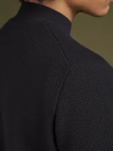 Sweater de punto color azul marino, con cuello alto y mangas largas.