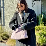 Bolso tipo tote color celeste con correa larga verde y asas cortas.