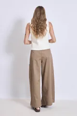 Chaleco de punto sin mangas, color rosado, con escote en V y cierre frontal de tres botones marrones.