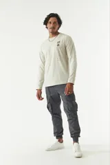 Remera de manga larga para hombre color beige, con cuello redondo y estampado en el frente. Confeccionada en algodón.