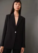Blazer azul eléctrico con cuello de pico con solapa, cierre de dos botones en la parte delantera, manga larga con puños abotonados y dos bolsillos delanteros de ribete y solapa.