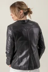 Campera azul de cuero ovino italiano, con cuello redondo, cierre frontal con broches ocultos, bolsillos laterales y detalle de capitoneado en puños y bolsillos.