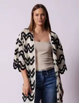 Cardigan largo de crochet color crudo con diseño de ondas en negro.