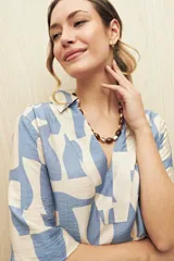 Vestido corto con estampado de rayas onduladas en blanco y azul, cuello tipo solapa y escote en V.