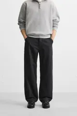 Pantalón de jean negro, corte relaxed fit, con bolsillos frontales y traseros tipo parche, tira multifunción y bolsillo tipo parche en las piernas. Tiene efecto lavado y cierre frontal con cremallera y botón.