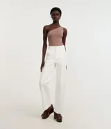 Body básico color durazno, con escote asimétrico y un solo hombro. Confeccionado en microfibra de poliamida y elastano.