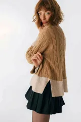 Sweater color camel con tejido de trenzas y terminaciones en color beige.
