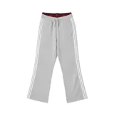 Pantalón deportivo gris jaspeado, estilo jogging, con corte ancho y tres franjas blancas verticales a lo largo de las piernas. Presenta un forro interior de tela escocesa roja y negra visible en la cintura.