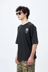 Remera azul con efecto gastado, corte holgado y estampado pequeño de flor en el pecho.