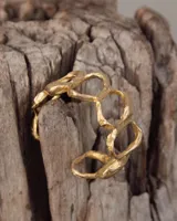 Brazalete dorado con diseño de círculos irregulares.