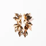 Aros colgantes dorados con forma de hojas y detalle de perla en la parte superior.