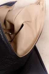 Bolso hobo reversible color azul marino, con textura símil cuero y correa bandolera extraíble.