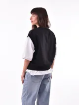 Chaleco negro con escote en V y bordado con la frase "Leisure and Relax Co." en el pecho.