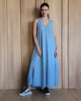 Vestido largo celeste de denim con breteles finos, escote en V y aberturas laterales.