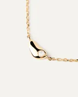 Collar dorado con cadena fina y dije pequeño en forma de lágrima con incrustaciones de circonitas.