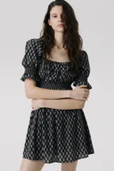 Vestido corto de crepé de algodón con estampado floral en blanco y negro, escote cuadrado con volantes, mangas cortas abullonadas con elástico en los puños, cuerpo ajustado con elástico y falda con vuelo.