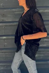 Remera negra con brillo dorado, de mangas cortas y escote en V.