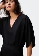 Blusa color crema con escote en V y mangas cortas amplias.