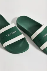 Sandalias tipo chinelas de goma color verde con banda horizontal blanca y logo de la marca CaroCuore en el lateral.