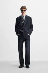 Corbata ancha de seda a rayas en tonos azul marino, marrón y gris.