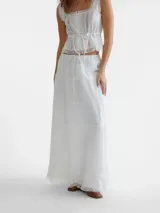 Falda maxi blanca de algodón con volados de encaje en el ruedo.