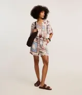 Short de cintura alta confeccionado en viscosa estampada con motivos tropicales. Tiene elástico y lazo en la cintura.