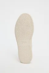Zapatillas deportivas color beige, con suela alta de 3 cm y cierre con cordones.