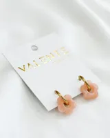 Aros dorados con dije de flor color durazno.