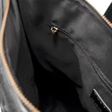 Mochila negra de poliéster con diseño tejido formando rombos. Tiene formato rectangular, acceso con cierre, correa regulable y asa fija. Cuenta con un bolsillo interno con cierre y dos abiertos, herrajes plateados, un compartimento y logo de XL Extra Large al frente en símil cuero.