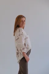 Camisa beige con estampado batik en tonos marrones, de corte holgado, cuello mao y mangas 3/4.