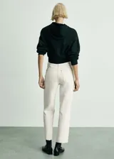 Pantalón de jean color crudo, de corte recto, tiro medio y largo cropped. Presenta cinco bolsillos, trabillas para cinturón y bajo desflecado.