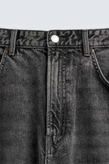 Pantalón de jeans de algodón, corte baggy fit, tiro medio, con efecto lavado en tonos grises y verdes. Presenta cinco bolsillos y cierre frontal con cremallera y botón.