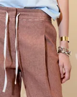 Pantalón azul de lino y algodón, con pinzas, corte recto y cordón ajustable en la cintura.