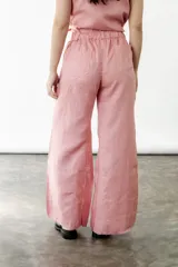 Pantalón wide leg color coral rosa, confeccionado en lino. Presenta tiro medio/alto, elástico en la espalda y godets en los bajos.